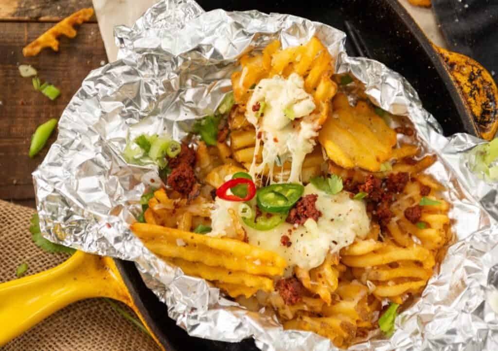 Overhead of loaded foil wrapped fries.