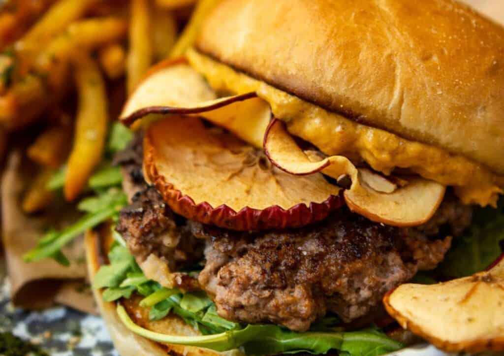 Close up of pork burger with toppings.