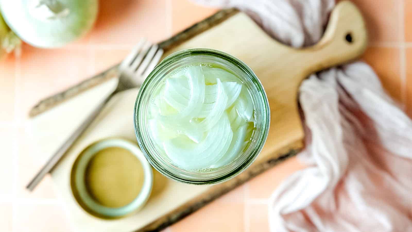 Pickled white onions in a glass jar.