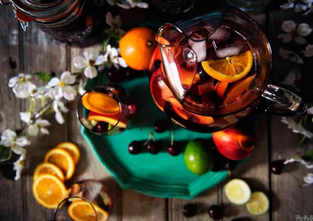 Overhead of a pitcher or red wine sangria with fruits.