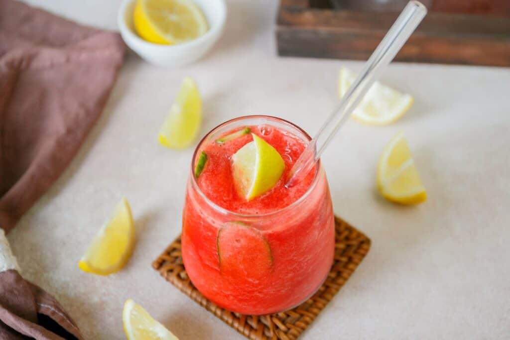 Nigerian Chapman, a vibrant pink-colored drink served in a glass with ice and citrus garnish.