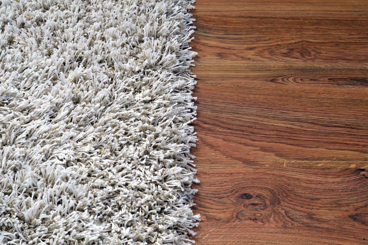 A picture of a white shag rug on a wooden floor.