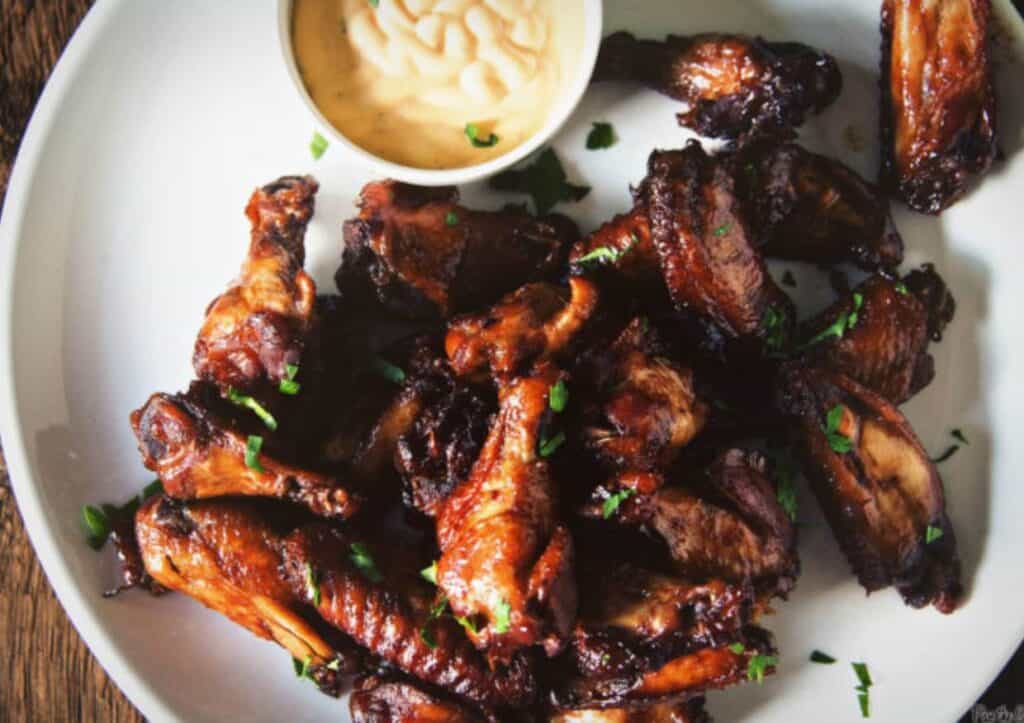 Platter of chicken wings with sauce.