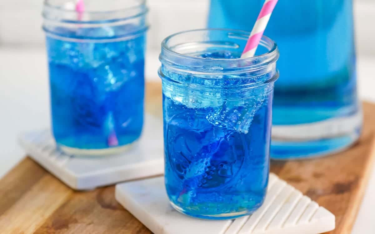 Sonic ocean water in a mason jar with a pink straw and more in the background.