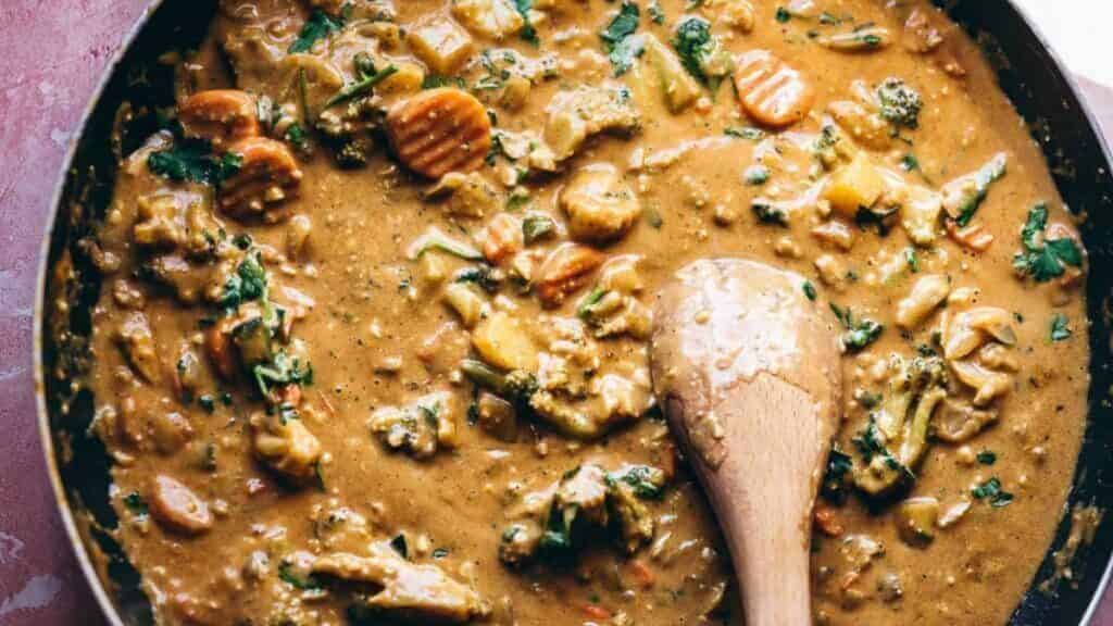 A curry skillet prepared with a wooden spoon, featuring an enticing combination of flavors.Keywords: curry skillet