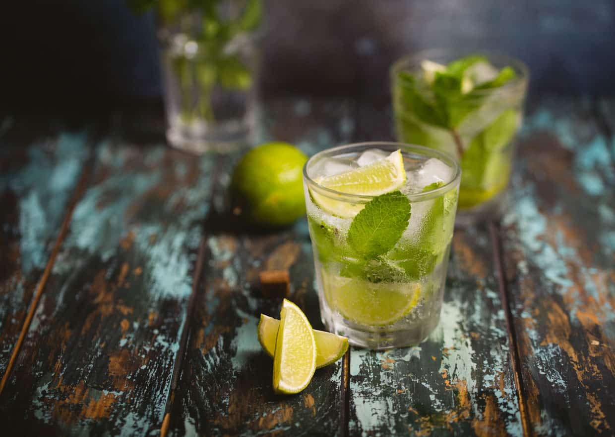 Two glasses of mojito on a wooden table.