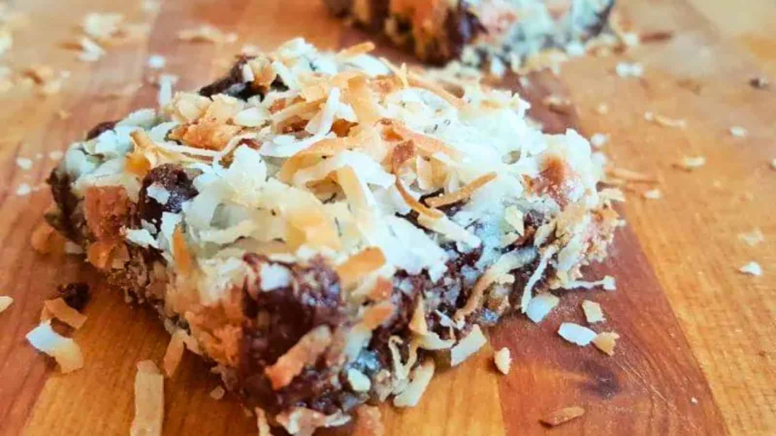 Image shows 7 layer bars on a wooden cutting board.