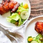 A plate of grilled chicken and salad on a wooden table.