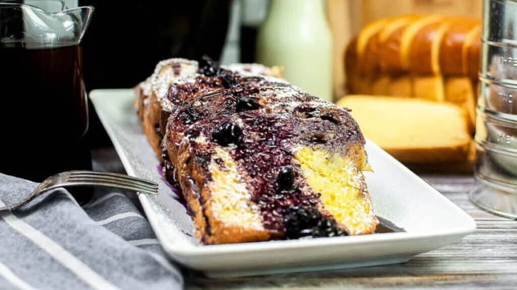 A slice of blueberry french toast on a white plate.