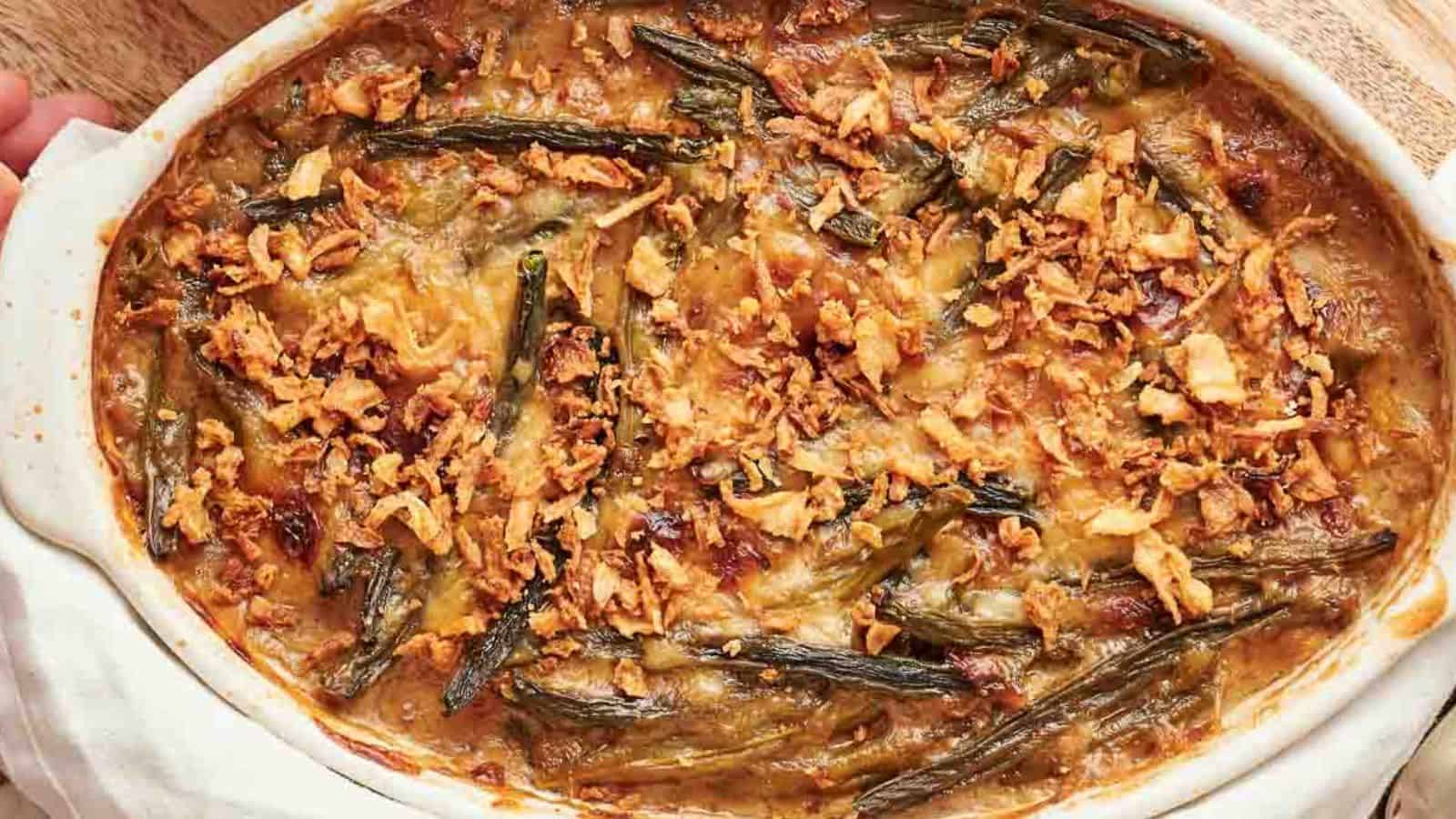 A white dish with green bean casserole in it.