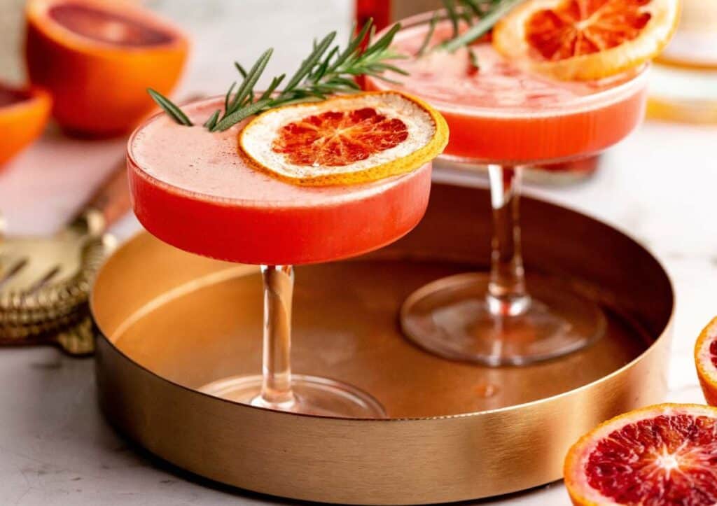 Blood orange Amaretto Sour with rosemary sprigs.