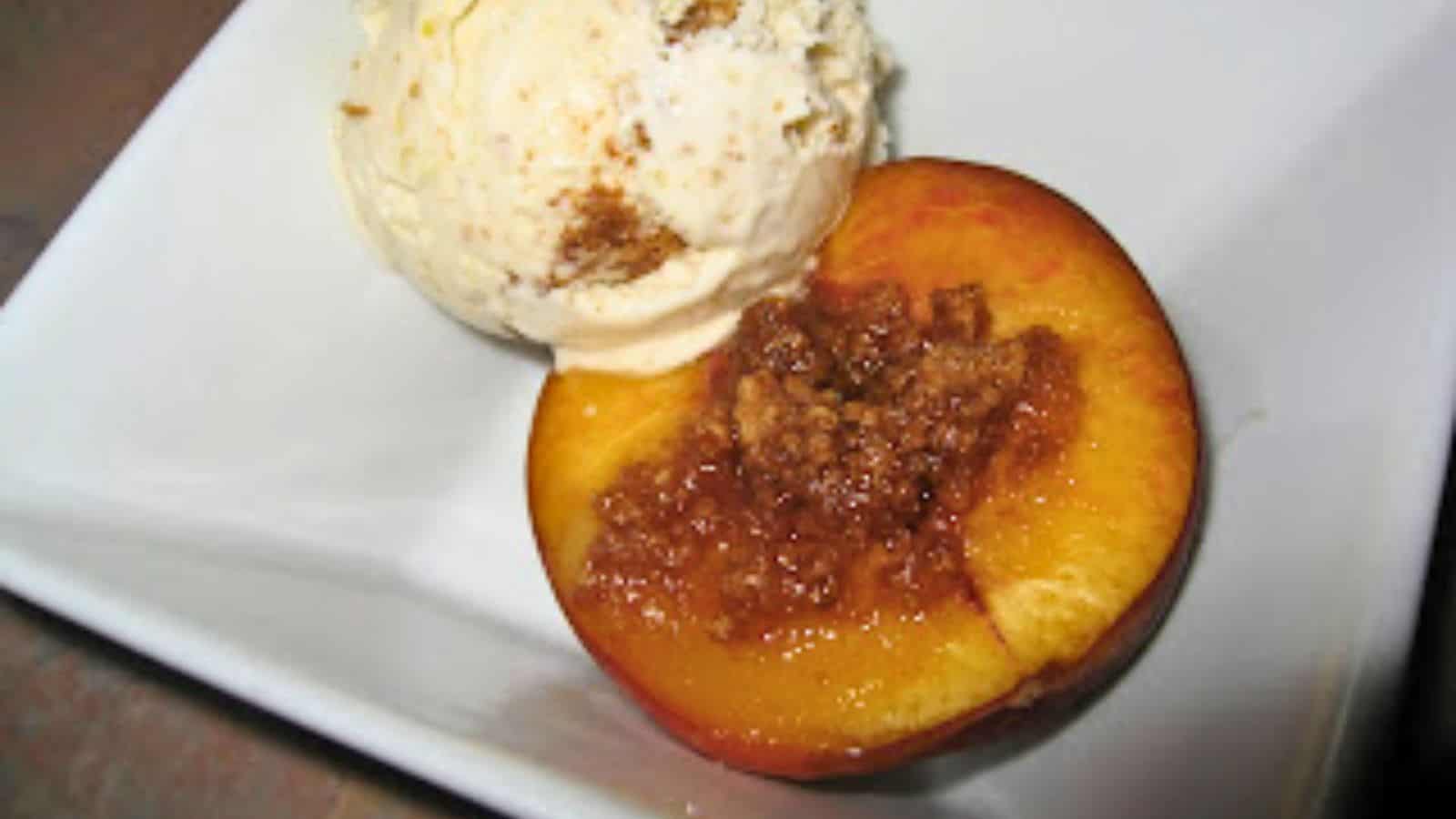 Image shows A baked peach with a scoop of ice cream.