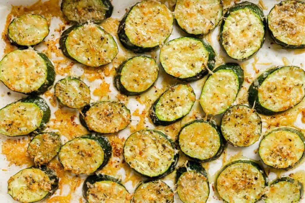 Baked sliced zucchini on a baking sheet.