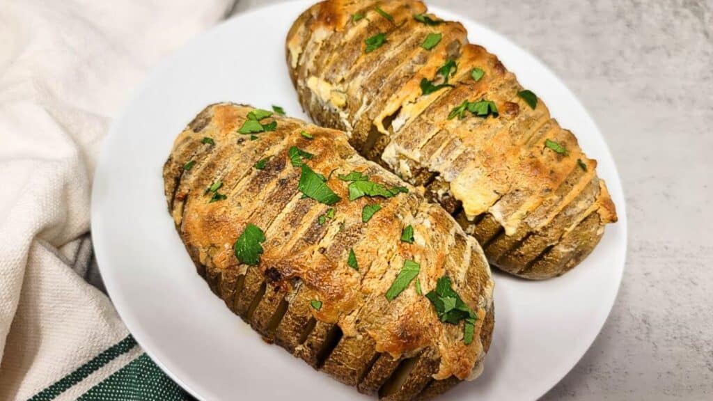 A plate with two Boursin hasselback potatoes