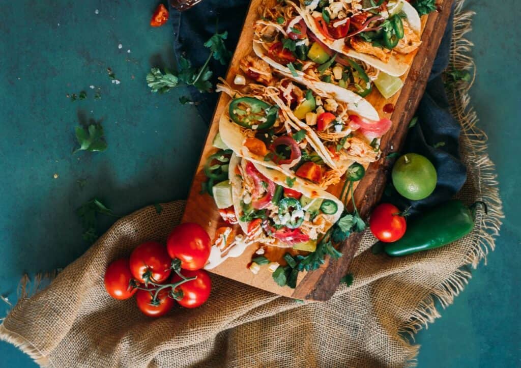 Mexican tacos on a wooden cutting board.