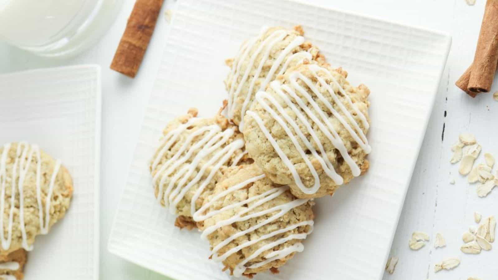 Apple oatmeal cookies with icing and cinnamon on a white plate.