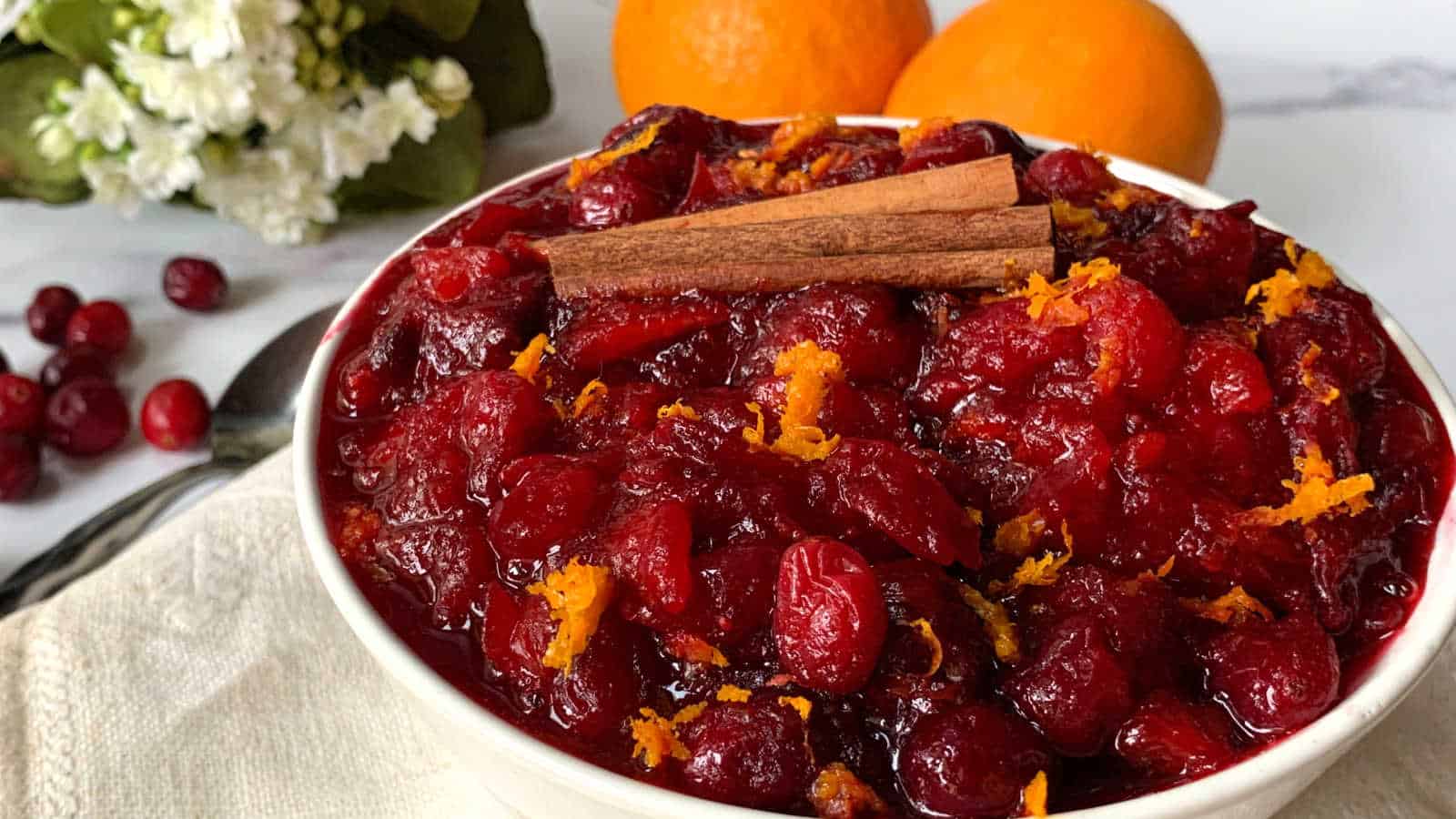 A bowl of cranberry sauce with oranges and cinnamon.