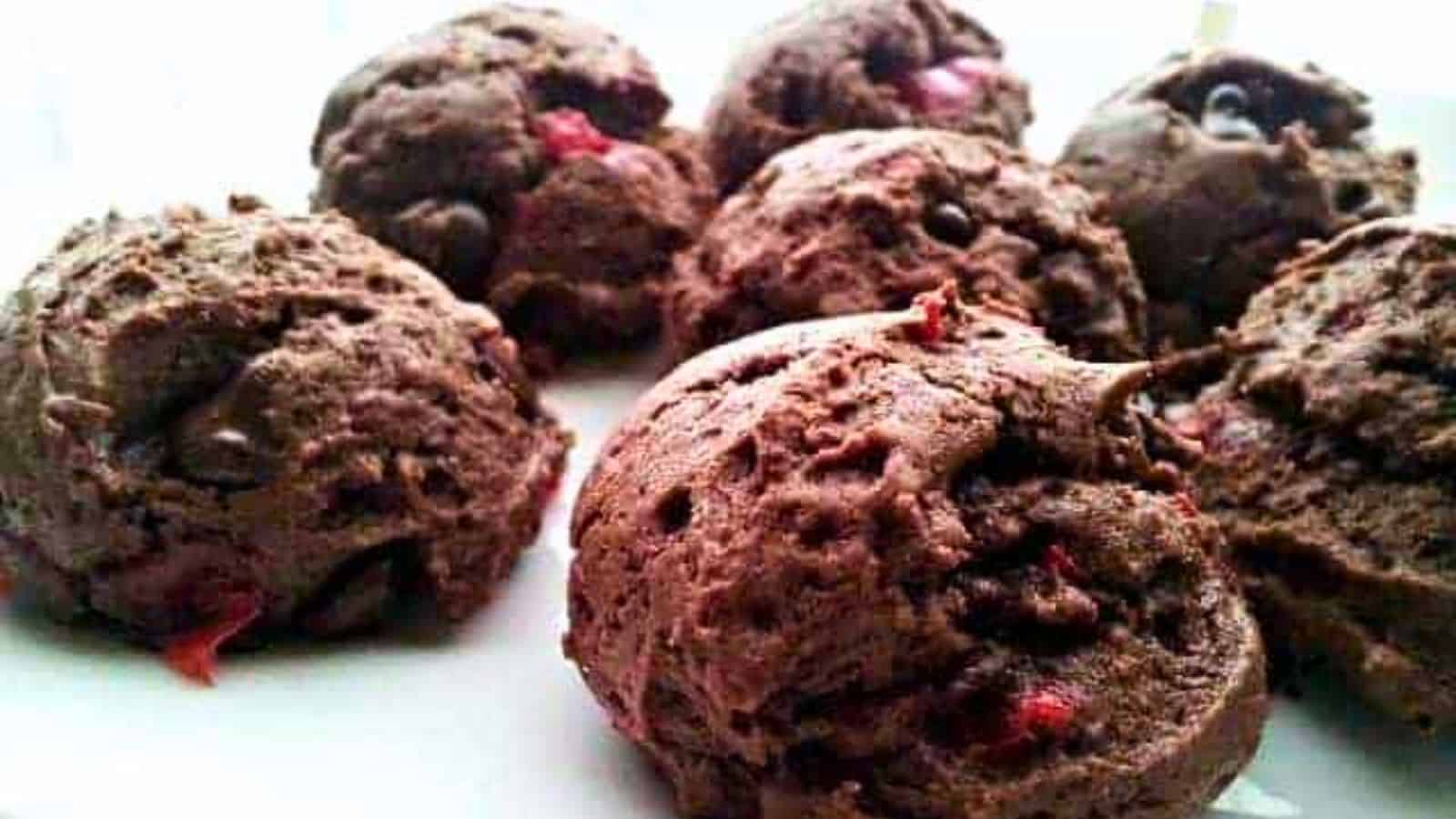 Image shows double Chocolate chunk cherry cookies on a white plate.