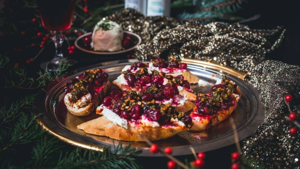Cranberry and goat cheese crostini on a silver plate.