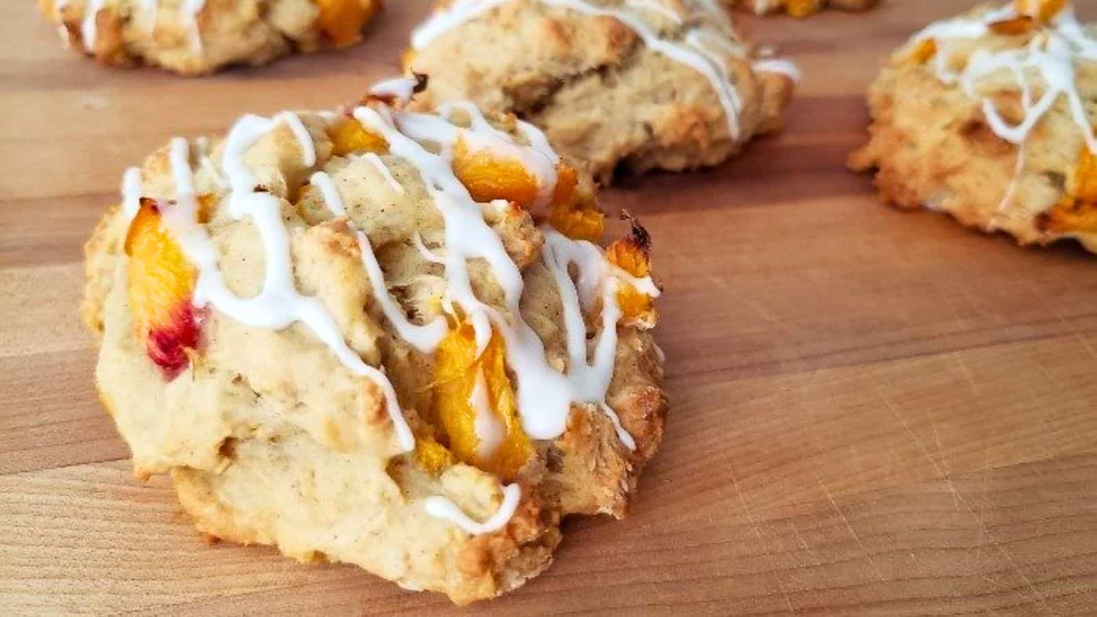 Image shows  Peach scones with icing on a cutting board.