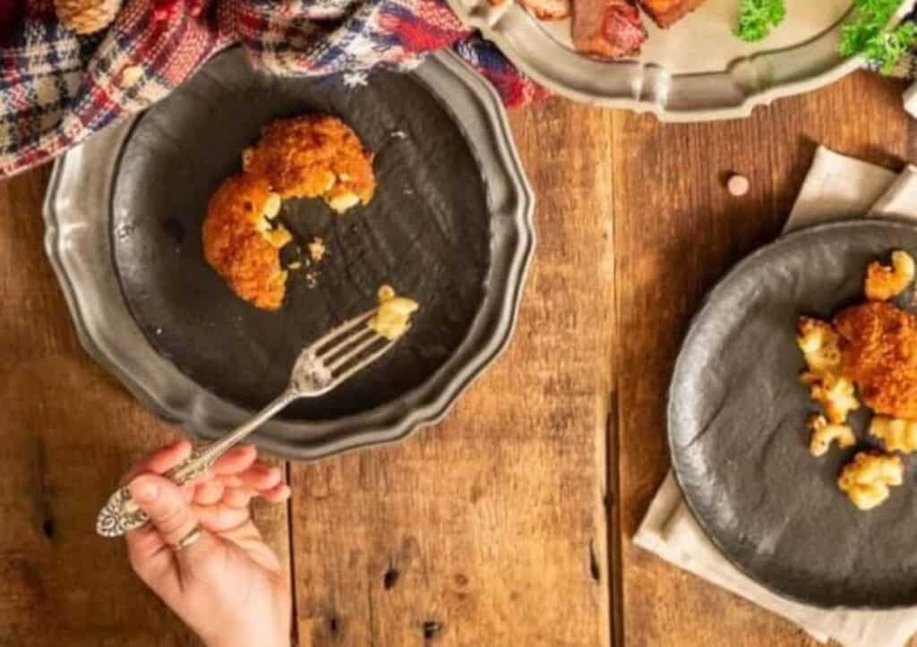 A person is holding a plate of food and a fork.