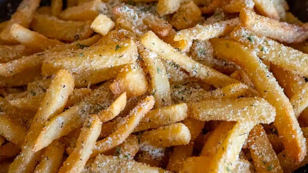 A close up of french fries with parmesan cheese.