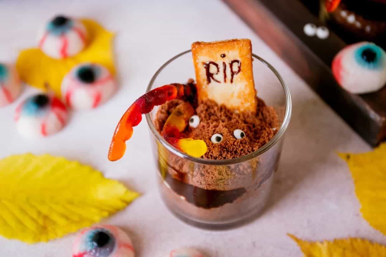 A glass of Halloween dirt pudding with an RIP cookie on top.