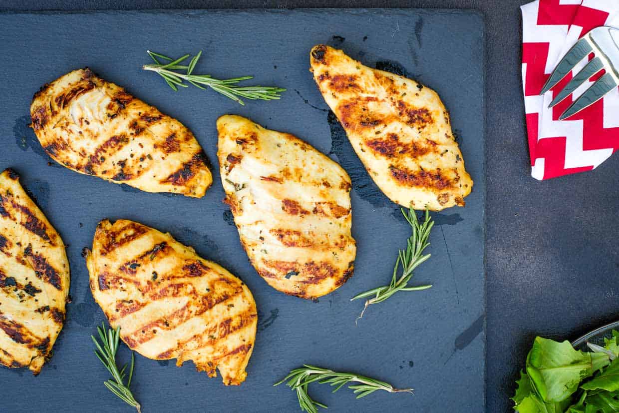 Grilled maple mustard chicken on a blue slate surface. 
