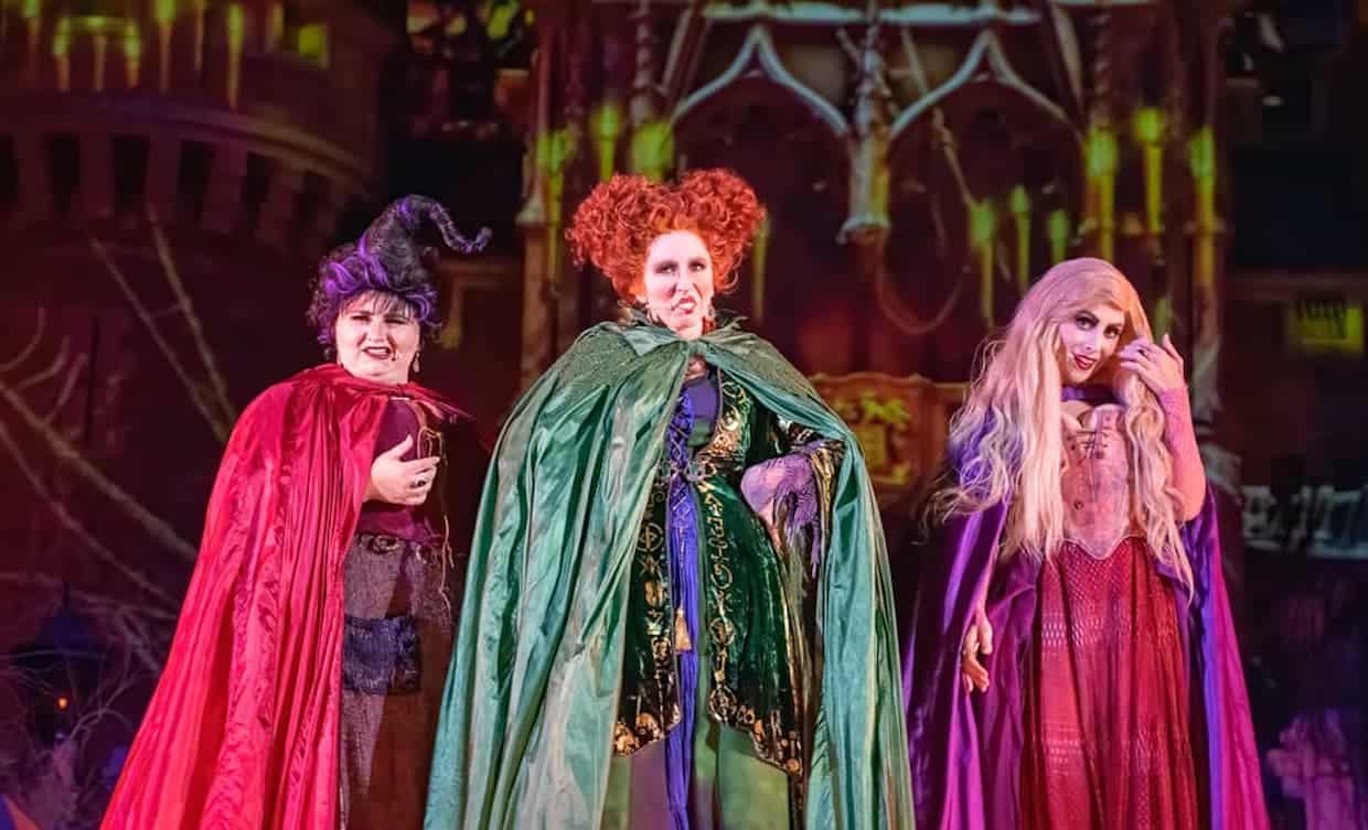 Three Halloween-themed witches dressed in costumes for a "Hocus Pocus" party.