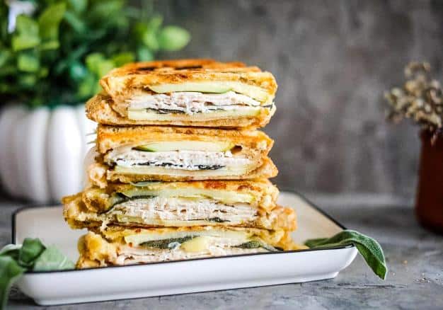 A stack of Turkey & Apple Paninis on a plate.