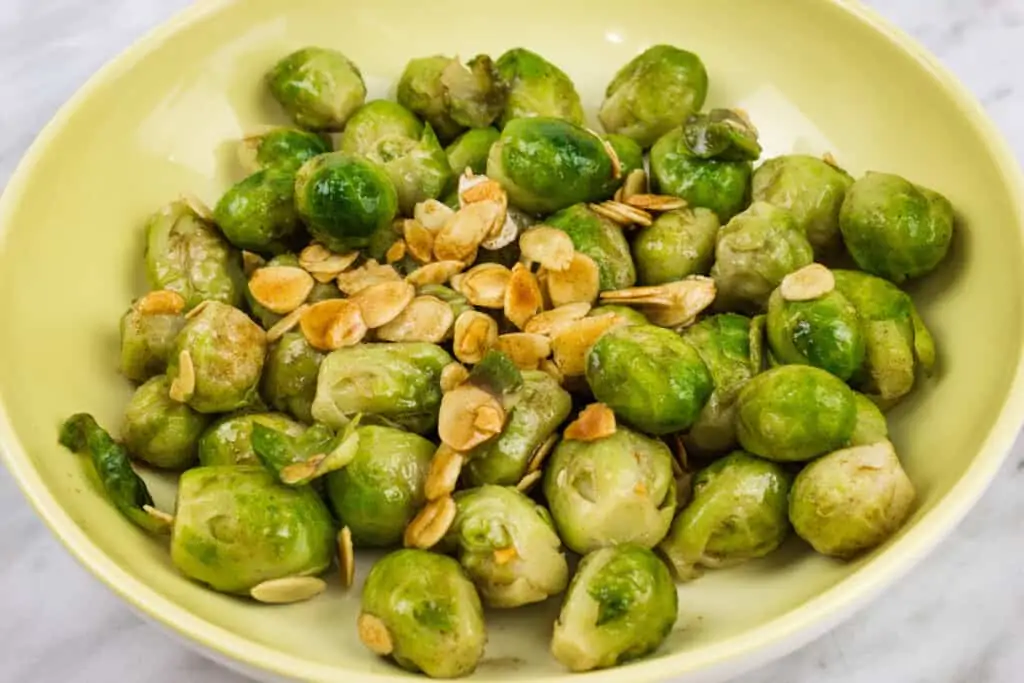 Brussels Sprouts with Brown Butter & Almonds in a shallow yellow bowl.