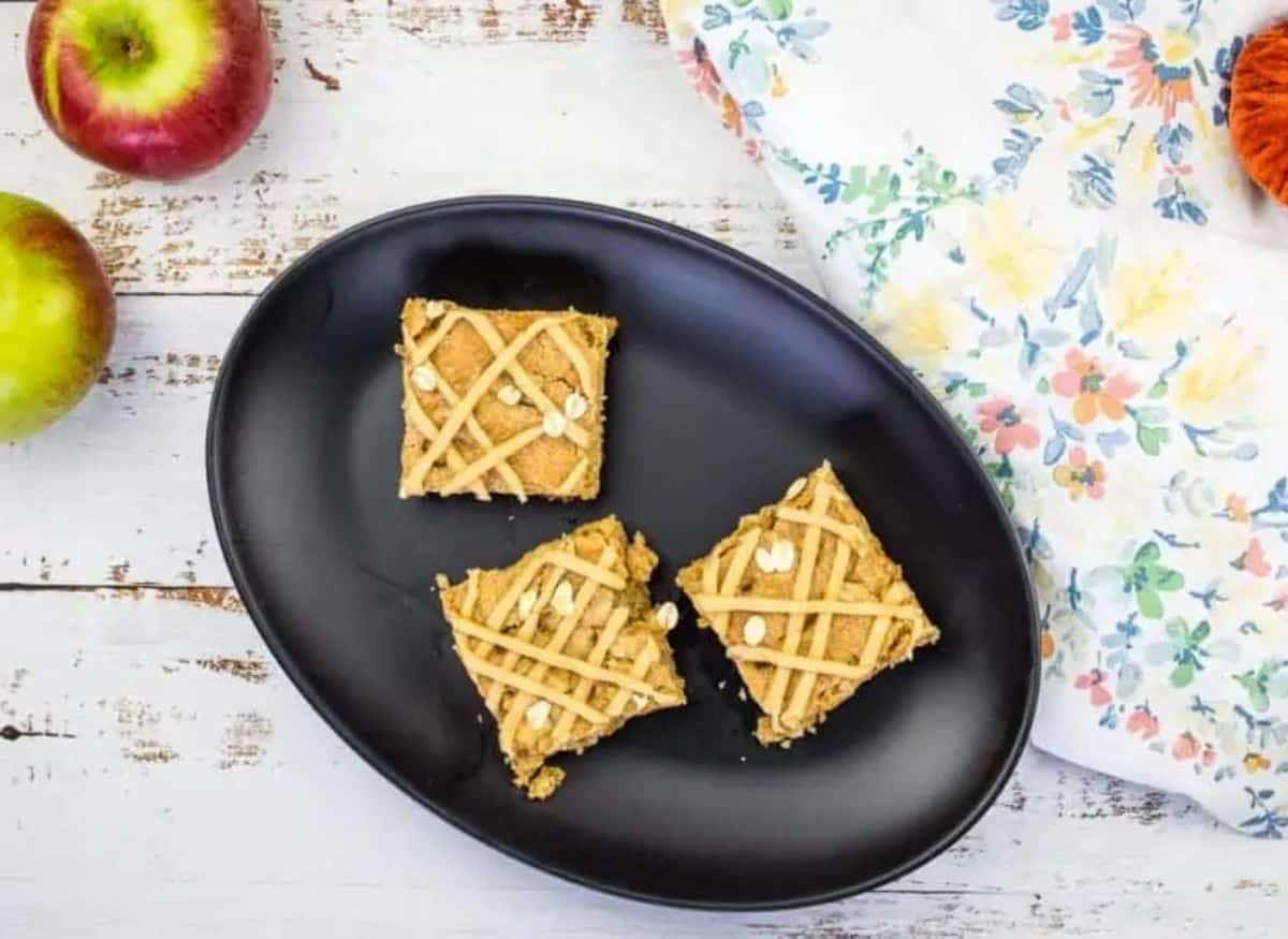 Brown butter apple blondie squares on a black plate.