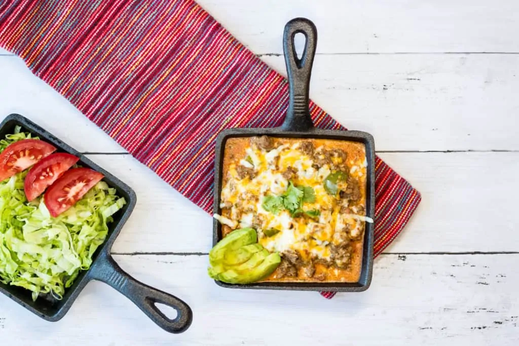 A skillet with Tex Mex Beef Casserole and a bowl of salad.