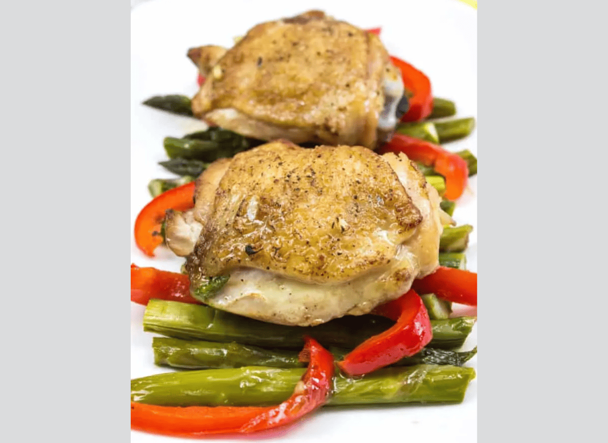 Garlic Chicken Skillet with peppers and asparagus on a white plate.