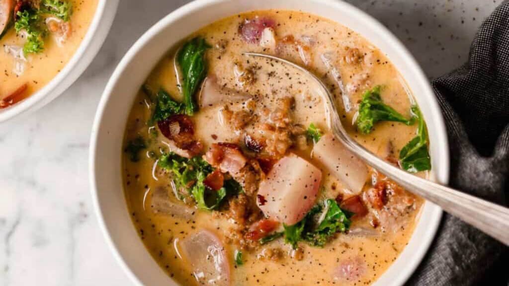 Two bowls of soup with bacon and kale.