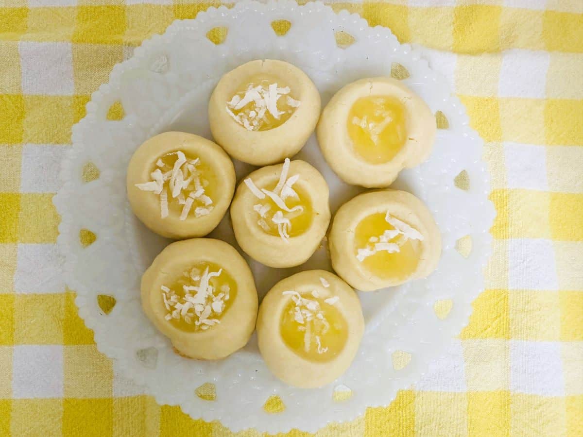 Lemon cookies on a plate with a yellow checkered tablecloth.