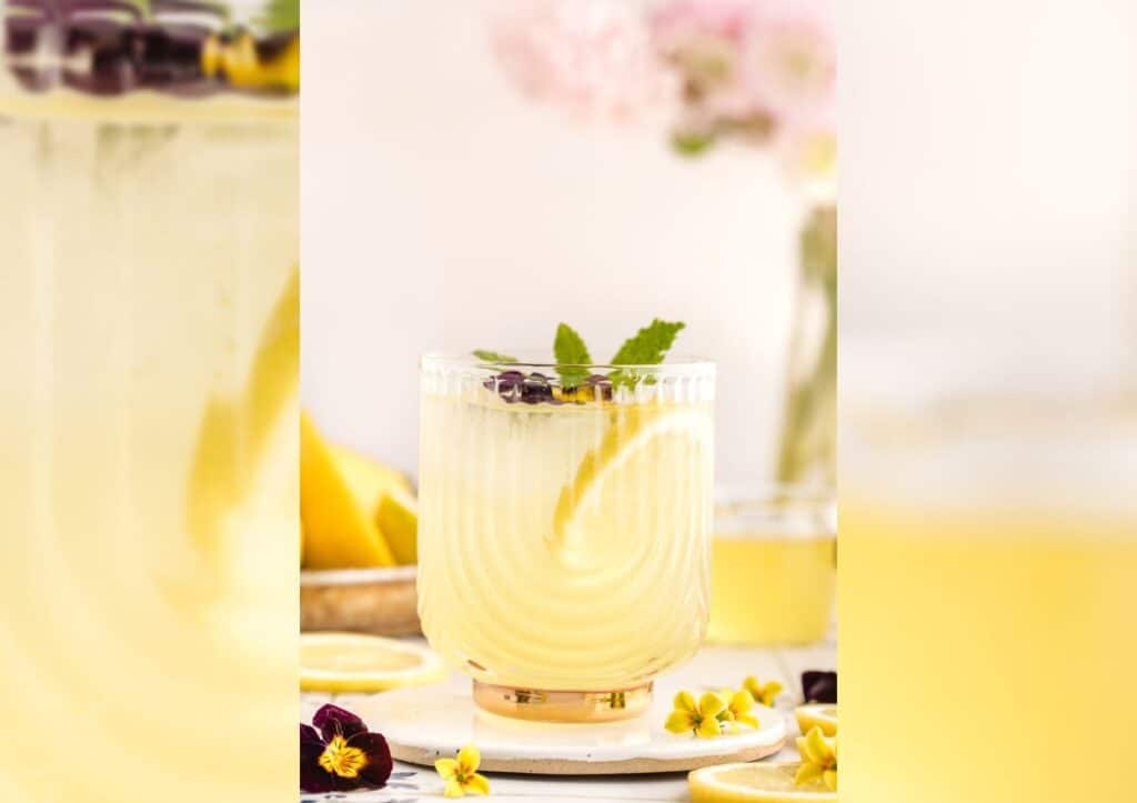 A glass of limoncello spritz with flowers and lemons.