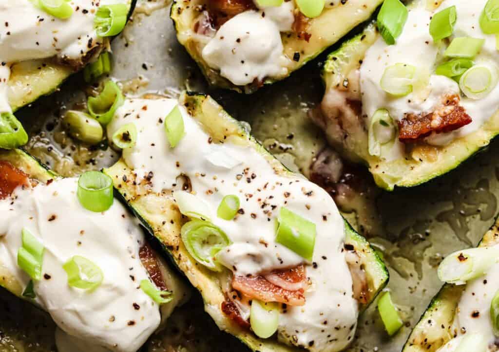 Zucchini boats stuffed with bacon and sour cream.