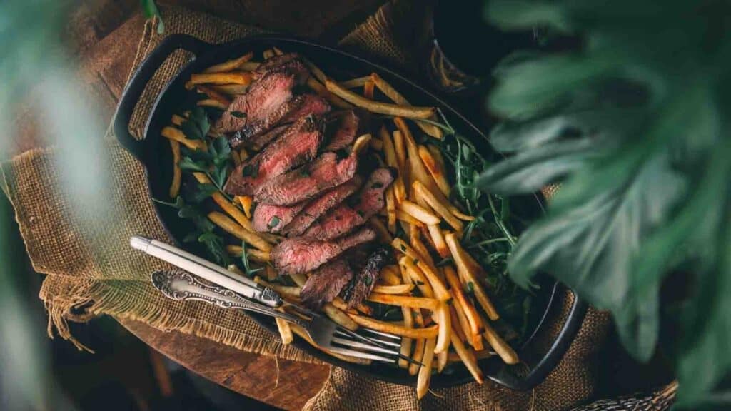 Steak and fries in a cast iron skillet.