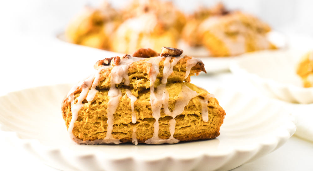 Pumpkin scones with icing on a plate.