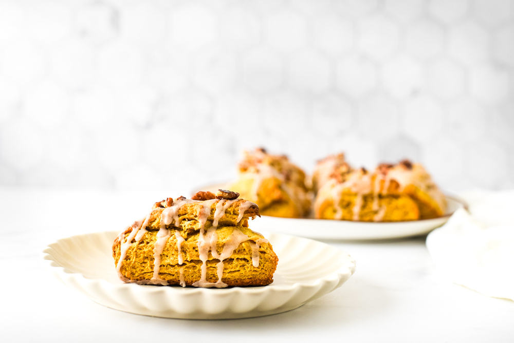 Pumpkin scones with icing on a plate.