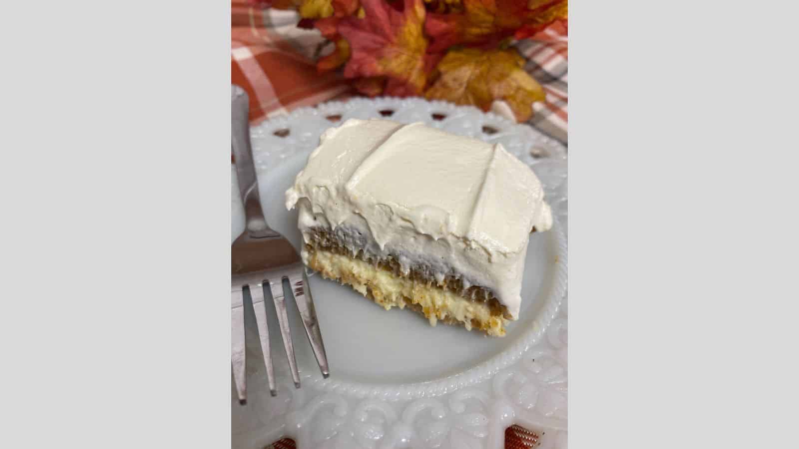 Slice of pumpkin torte on white plate with fork.