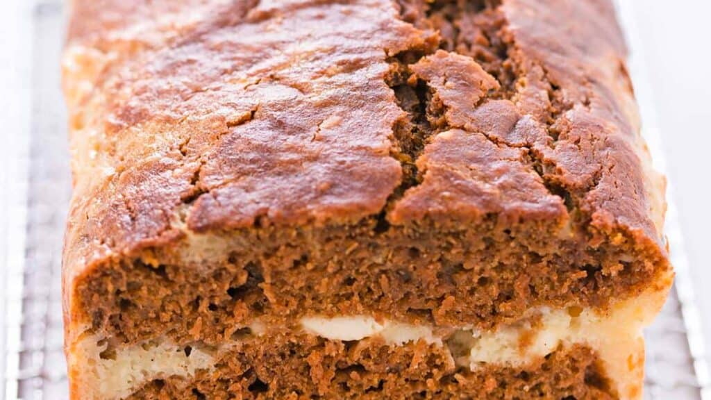 A slice of pumpkin bread on a cooling rack.