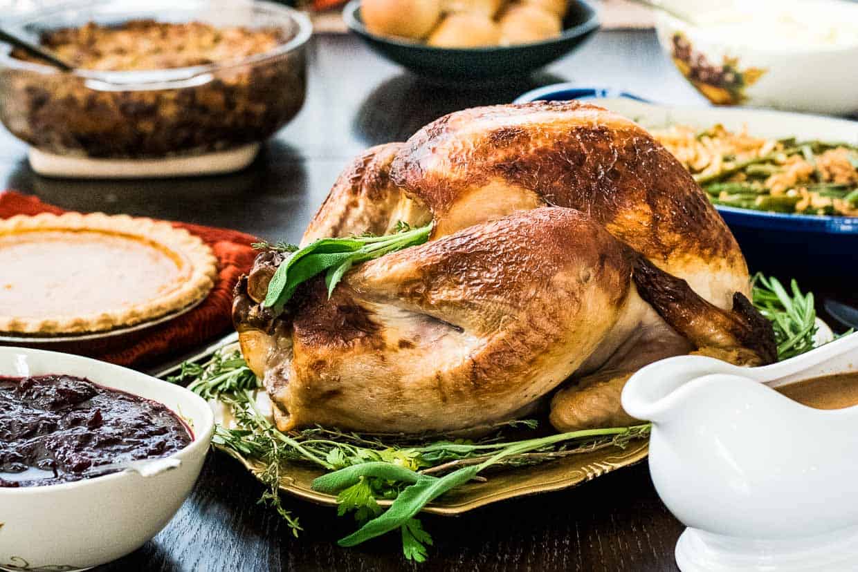 A buttermilk brined roasted surrounded by festive holiday side dishes.