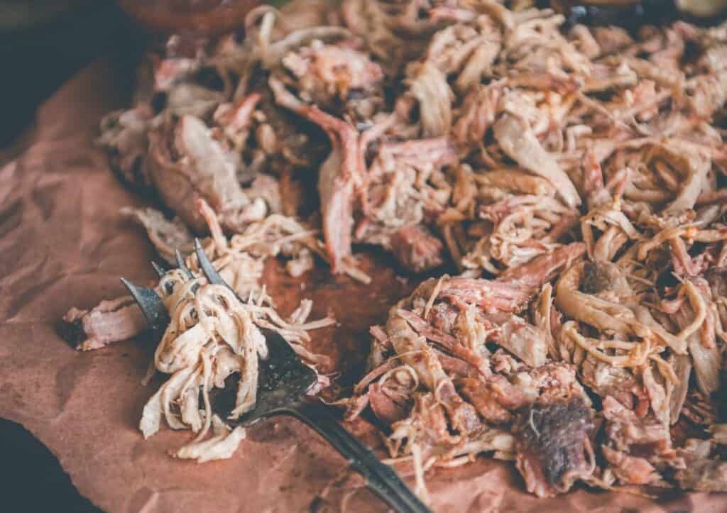 Pulled pork on a plate with a fork.