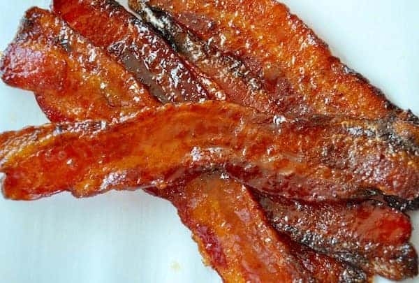 A plate of bacon on a white plate.