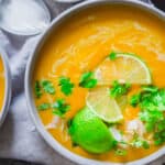 Two bowls of Thai buttercup squash soup with lime and cilantro.