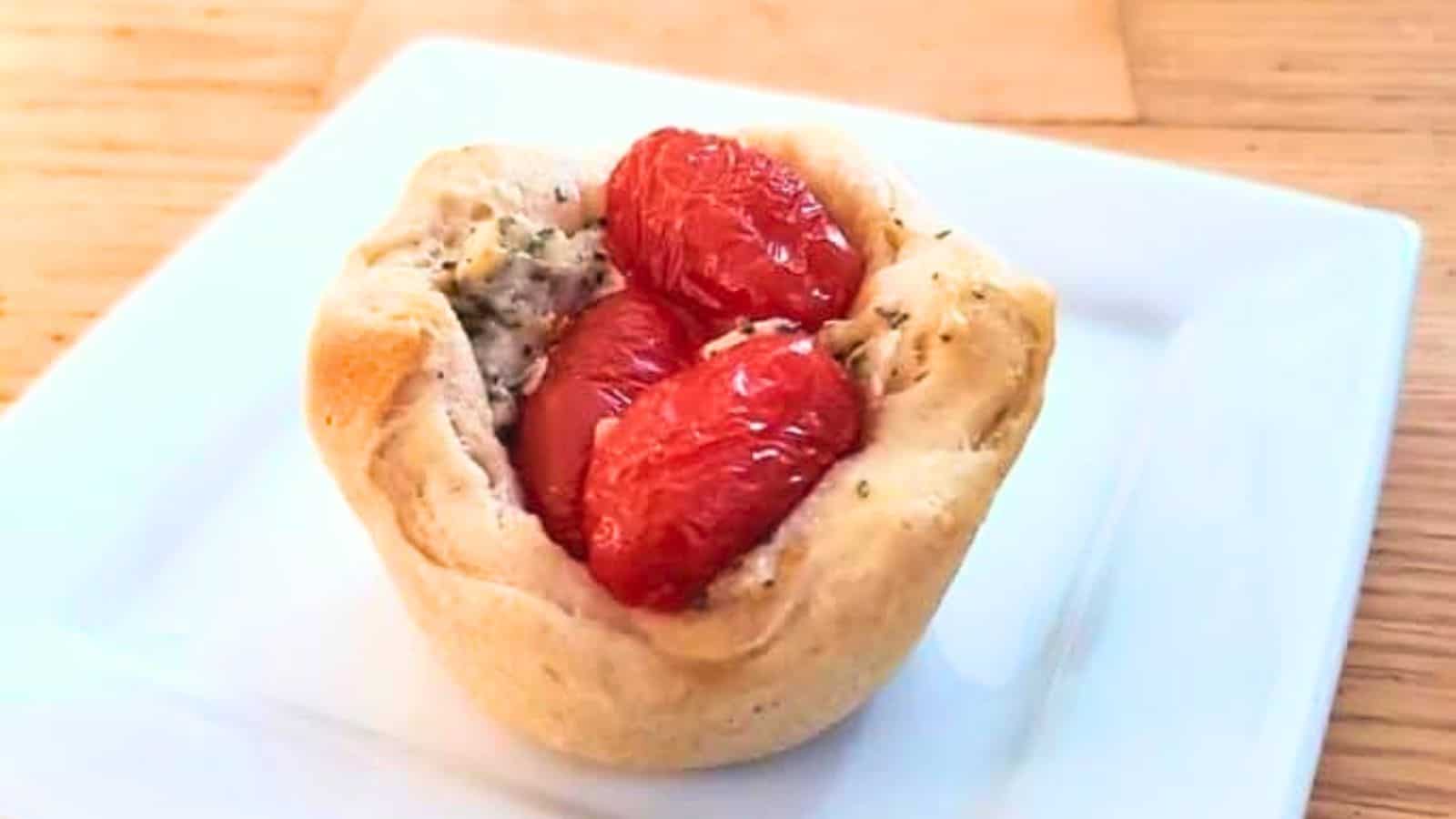 Image shows a Tomato Basil Biscuit Cup on a white plate.