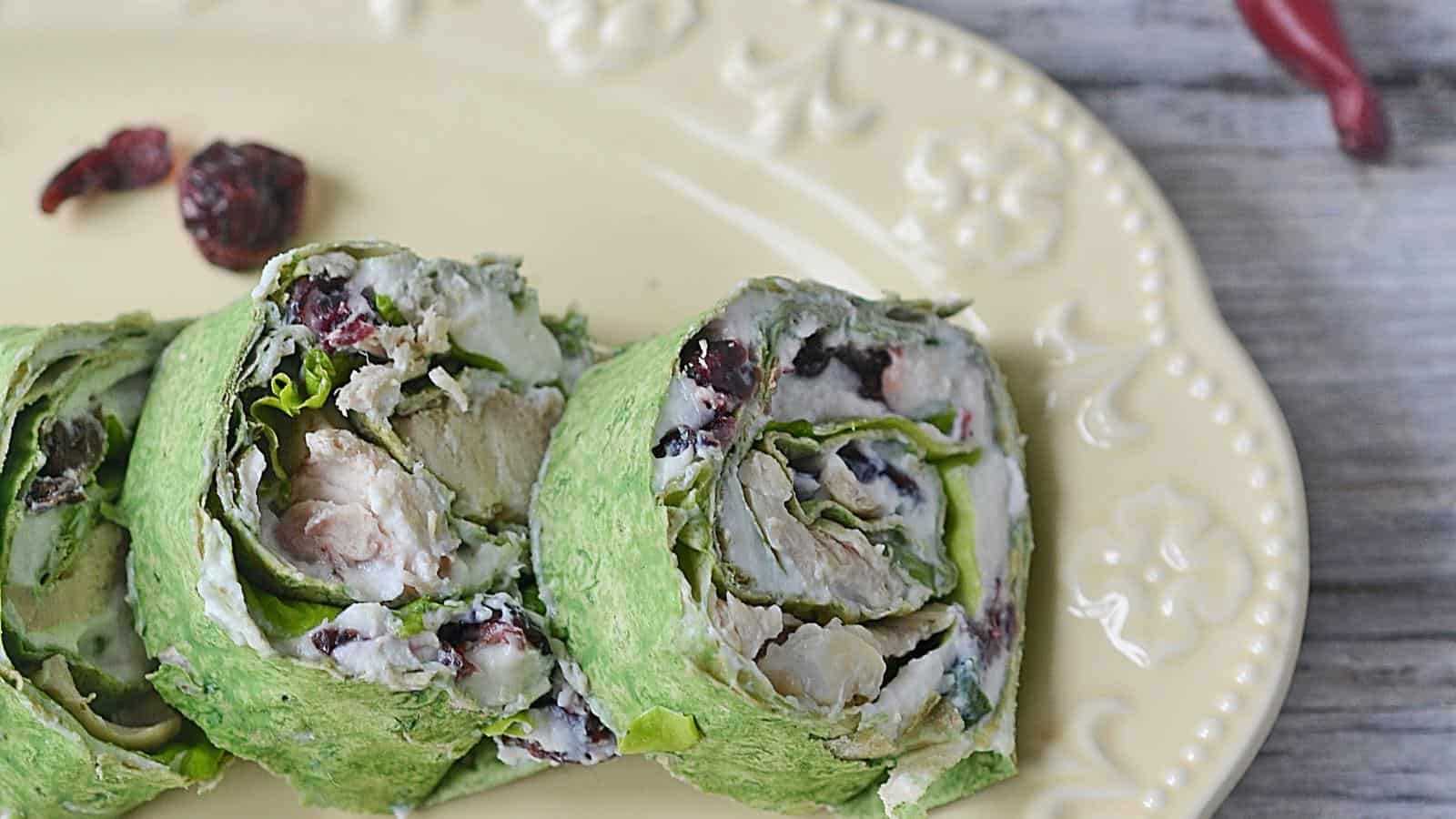 Cranberry chicken wraps with cranberries on a plate.
