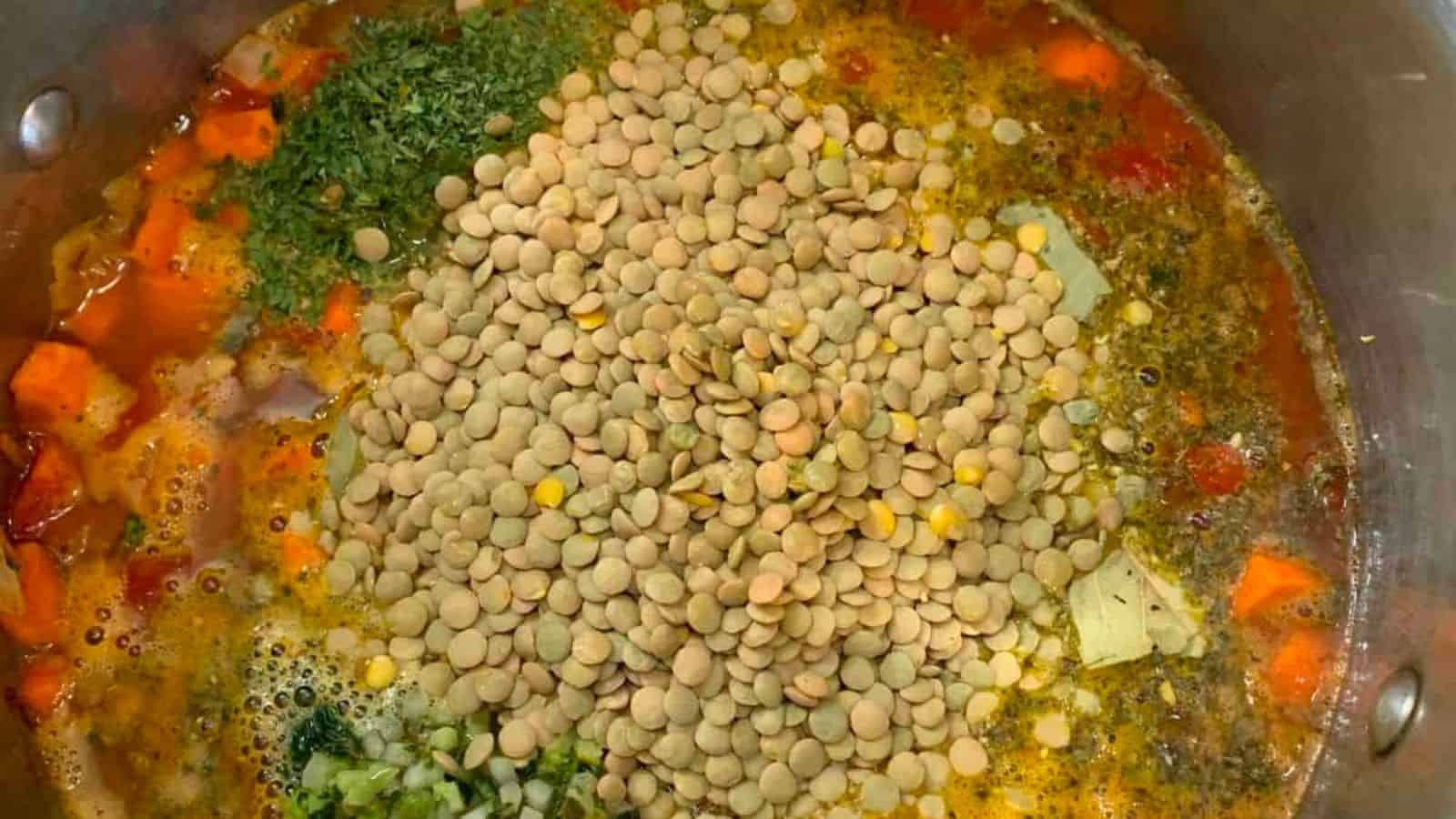 A pot of veggie lentil soup, filled with vegetables and lentils.
